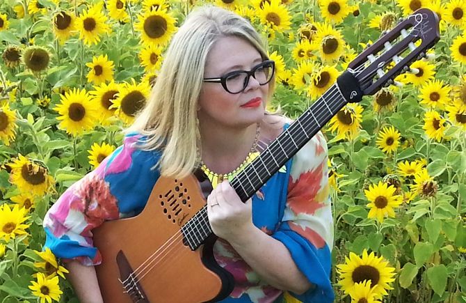 solo guitarist in field of sunflowers