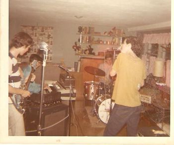Apocalypse in Scott's Basement, Spring 1970 ... and it's Scott and I playing with Larry Gallat and David Meyer. Scott, Larry and I all lived in the same neighborhood and went to the same scools together. We didn't meet David until tenth grade and (for me, at least) it was like meeting a lost twin brother. Here was a guy who not only played and sang well, but was into much of the same music as us. In this photo we're practicing "Flute Thing" by the Blues Project. Left to right: me on my first guitar, modified to quasi-bass tuning; Larry Gallat on Farfisa organ; Scott Kistenberger on his Gretsch drum set in its original champagne sparkle finish; and David Meyer on flute.

