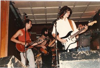 The Kim Strongin Band at Garvin's in Huntington, about 1982. This was a stripped down outfit, originally a band for backing up Kim's singer/songwriter stylings, but we soon became a basic bar cover band to make money. Two guitars, bass, and drums - a tight little equipment lineup, and a peppering of original songs to keep it interesting. left to right: Douglas Baldwin (guitar, vocals), Mike Guido (bass), Kim Strongin (guitar, vocals). Paul Shields can be seen on the right, sitting in on harmonica. to Kim's left. Keith Hurrell is in the back on drums.
