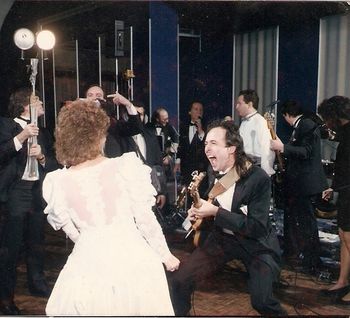 Being "the rock guitar guy" at a wedding, about 1985. Part of my schtick was to play some anthemic and appropriate rock song and rock out with the bride on the dance floor. Springsteen's "Glory Days" was the usual song. This became quite the event at an already huge event - you can see the photographers circlingwith their lights, capturing the bride's ability to get wild on her big day.
