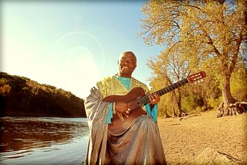 Siama playing guitar at his favorite spot by the Mississippi River in St. Paul, MN (photo by Dallas Johnson)

