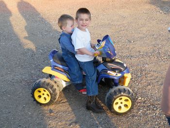 Grandson Christopher, age 4, with his little brother Leo (age 22 mos) taking a ride on ATV in Grandma's front driveway.
