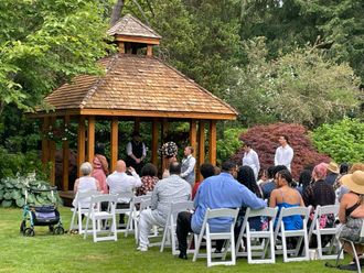 Outdoor Wedding Ceremony with Bride and Groom Exchanging Vowels and Guests Sitting Down
