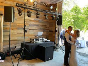 Bride and Groom Dancing to their First Dance at their Wedding Reception with DJ Equipment in the Back