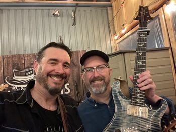 Dave showing off his new guitar to Michael.

