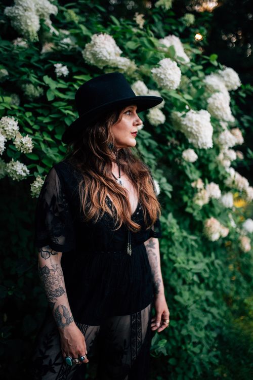 Americana musician Sarah King in Western hat with hydrangeas.