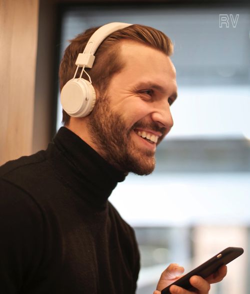 Man smiling with headphones and smartphone