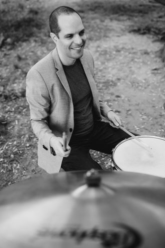 Dor Herskovits playing drums and smiling