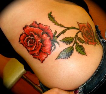 Thorny red roses on female hip
