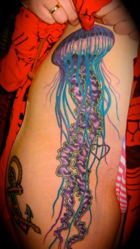 Jellyfish on female client's hip and leg (covering 7 hearts tattoo)
