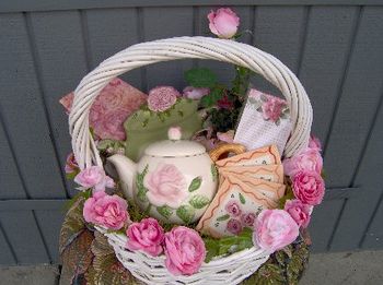 rose kitchen collection $ 20 inc tea pot & matching ceramic message center, magnetic note pad w matching magnet, 4 coasters, rose tissue paper in a white basket embellished with pink roses
