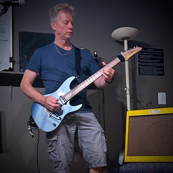 JD Stefan with his awesome, ice-blue Ibanez guitar, Prestige series.  (Photo by Tim Jones.)
