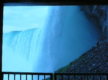 A blue shot of Niagara Falls from the bottom of the waterfall.
