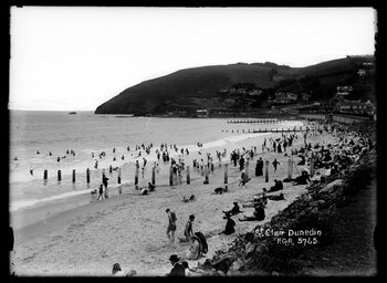 Looking along St Clair's Beach, Dunedin, towards Forbury Head. Showing crowds of people on beach, building sandcastles just like we do today  1917
