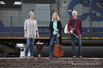 Moon Music signature photo. Captured by Joylyn Hannahs, Moon Music standing on a brick wall next to a LARGE idling vibrating diesel locomotive.  No photoshop, no "green screen", the real thing about three feet right behind us!

