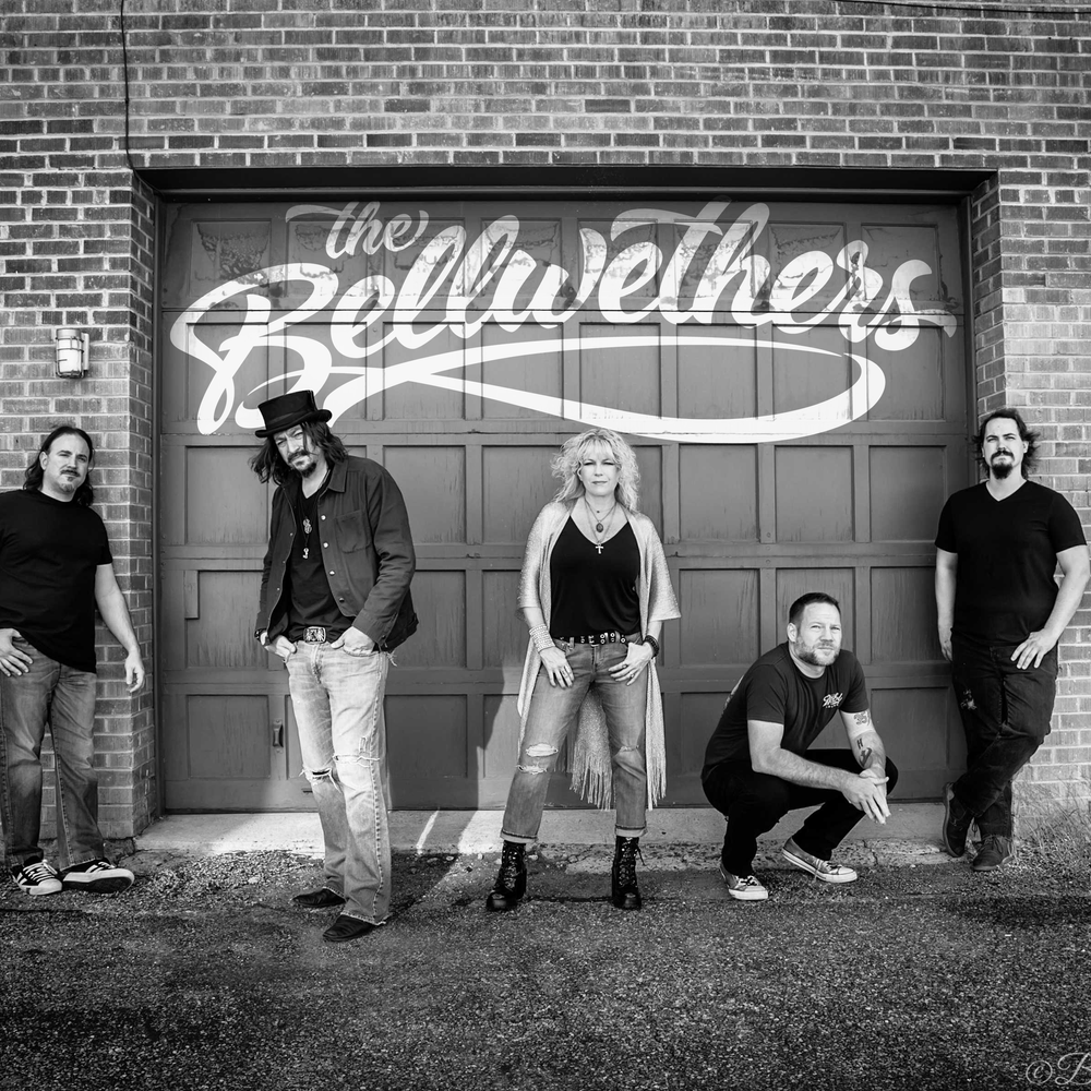 Arizona rock band The Bellwethers standing in front of a garage door with logo.