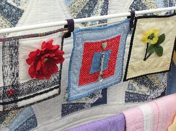 a close-up of my "Kitchen Art" - decorative potholders, with a fan quilt showing behind and small quilts below.  Photographed by Cynthia Nousak.
