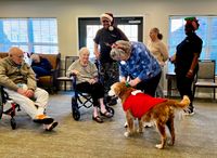 Marilynn Seits plays the piano for the residents of Givens WAL, accompanied by therapy dog, Xean.