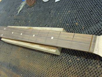 The old frets have been pulled, and the board is being prepped for new frets.....
