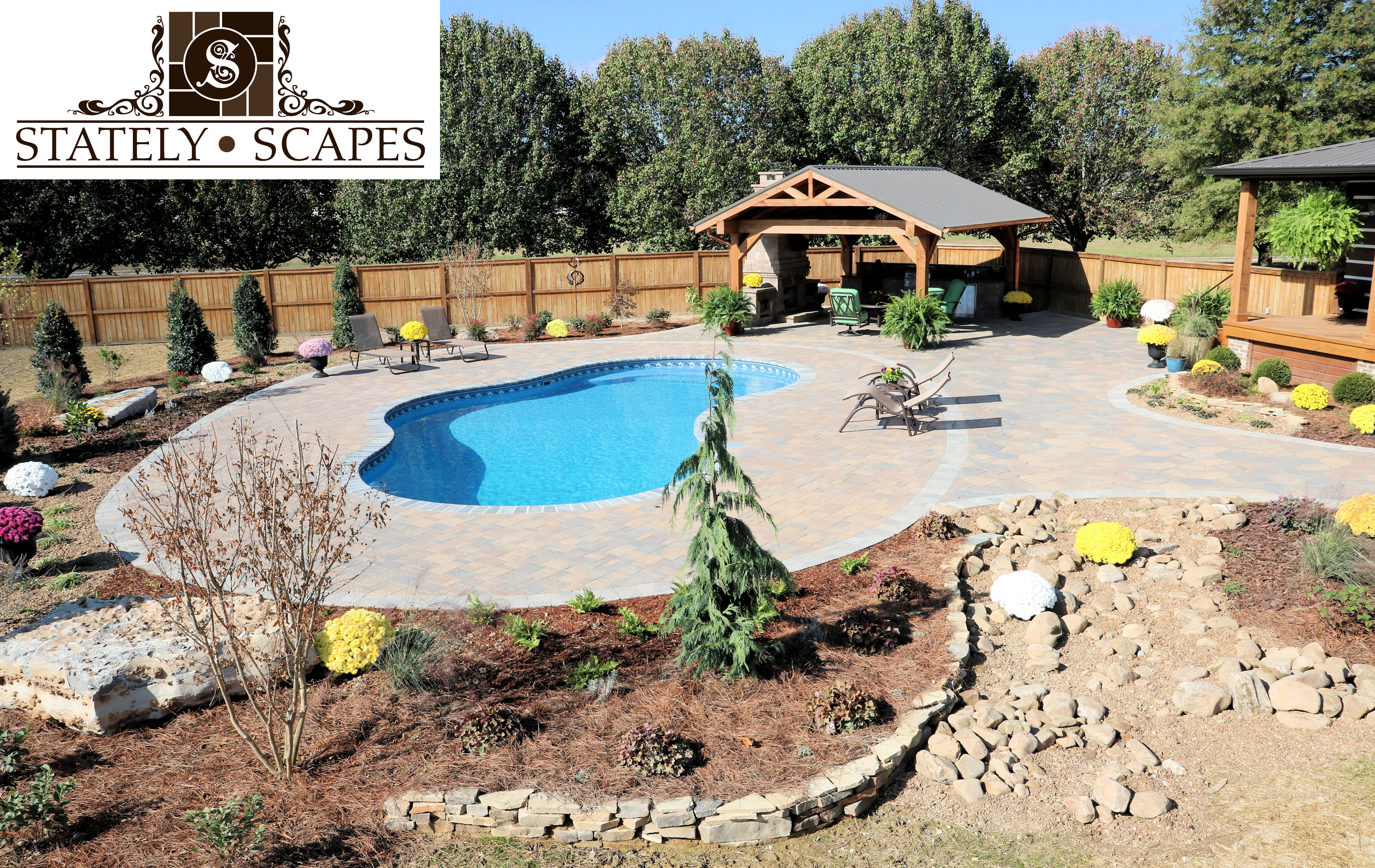 Matrix swimming pool with outdoor kitchen area and (Belgard Bristol) fireplace. Belgard Urbana & Arbel pavers used in patio area.