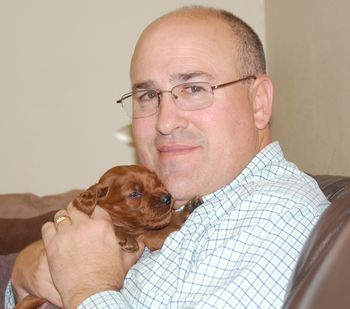 My husband Lenard holding a puppy.
