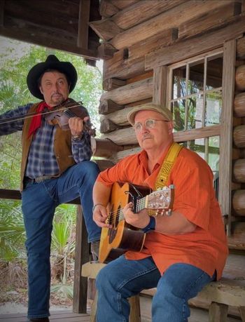 Playing on the porch of a log cabin and shooting a video of 'God Must Be a Cowboy'.
