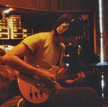 Gary records a guitar part using his yellow Hamer guitar in the control room.
