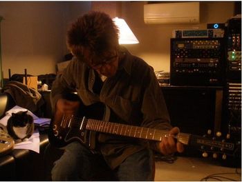 John lays down a part for "Wrong Idea" on his Dan Electro baritone guitar as Psycho the cat watches from the couch.
