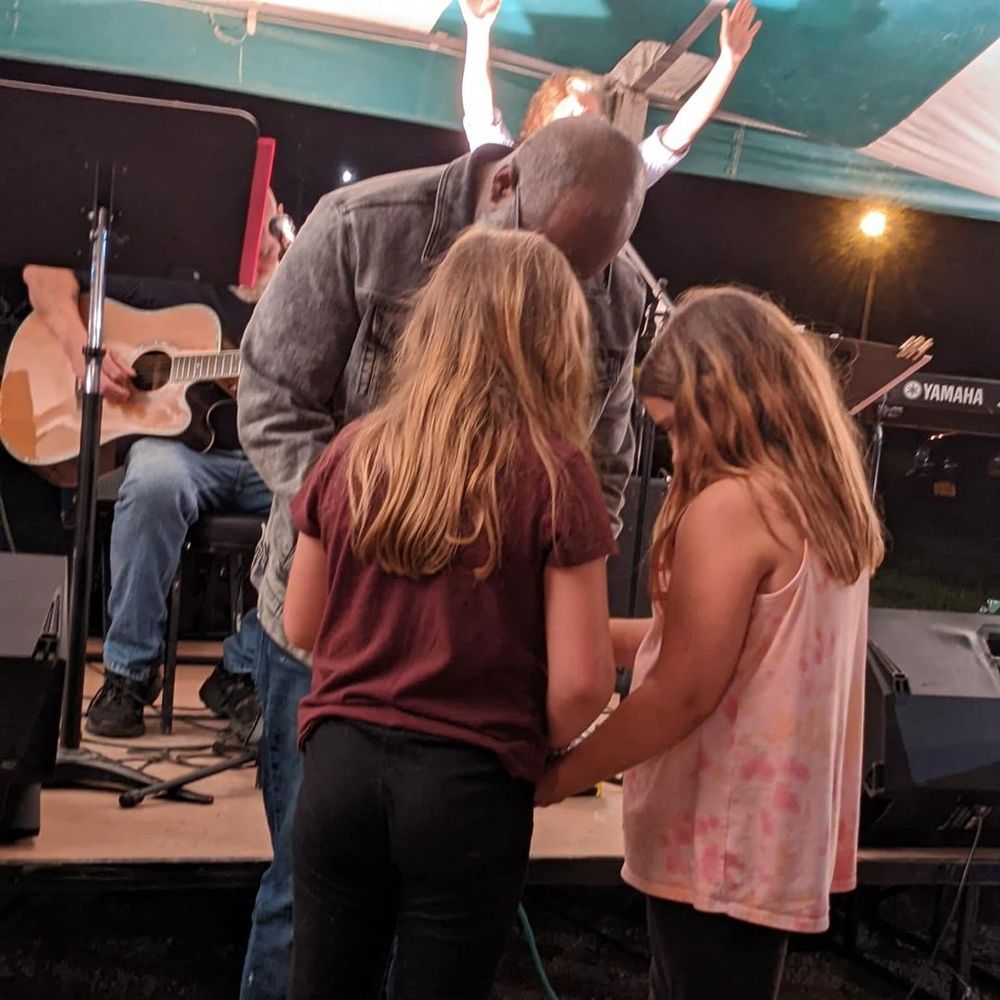 Pastor Douglas Smith brings children to Christ. Tent Meeting 2022