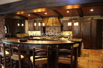 Custom Large Rustic Hammered Copper Kitchen Range Hood. 48 oz. copper with welded seams. Forged iron trim with custom clavos. Matching curved copper counter top. Location: Fresno, CA
