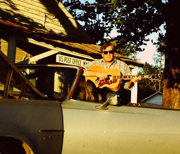 Just Livin' In These Hard Times...in front of the Manassas, GA post office in Kermit's Silver Bullet custom convertable...Sammy Johnson used a cutting torch to customisze the roof. That is my 1970 Gibson J200 guitar circa 1993.
