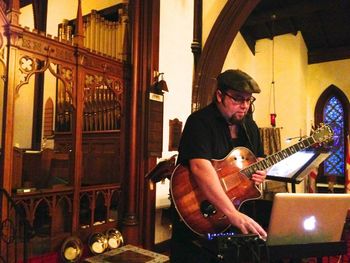 Setting up for our finale concert in All Saints Church, St. Andrews. Gerald uses his laptop to control his Triple Play pick up - the fabulous piece of tech that turns our guitar into an orchestra.
