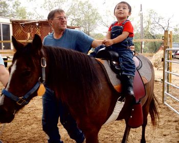 This is our grandson at 2-1/2 years old on his first pony ride. Lorenzo says a lot of things we can't understand yet, but he can clearly say "Rosie the pony". This pony is an 8 year old POA mare, you have to get right up to her to see her little tiny white spots, only a handful of white hairs in each spot. Unfortunately, this girl is just a bit too much for Lorenzo yet, and he prefers to get up on one of the bigger mares with me.
