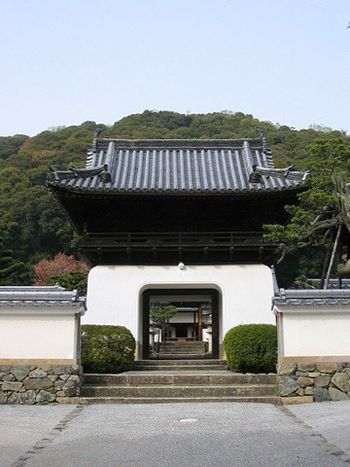 At the top of the hill is a white Chinese-style gate at the formal perimeter of the temple grounds.
