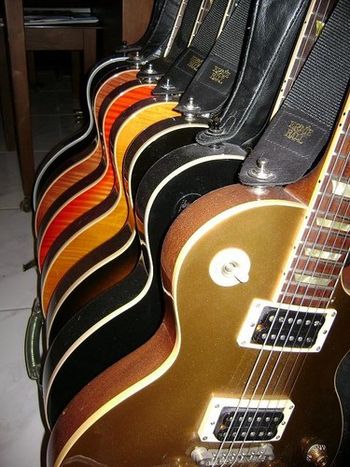 My rack of Gibson Les Pauls. (Back to front: Ebony Custom, Lightburst Standard Premium Plus, Heritage Cherry Classic Premium Plus, Transparent Amber Standard, Desertburst Standard, Ebony Classic, Goldtop Classic)
