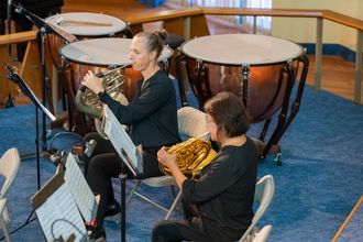 WOA French horn players viewed from above with timpani in backdrop