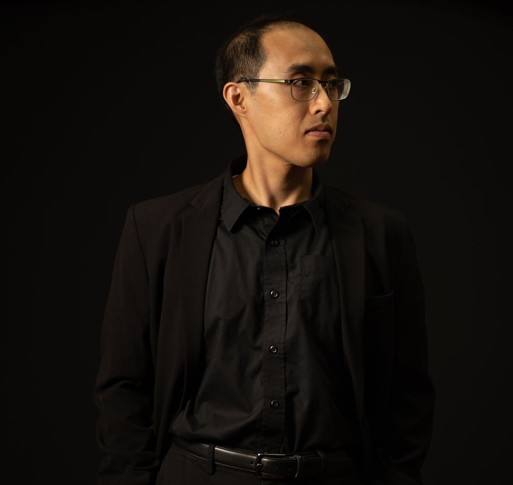 Alphonse Nguyen dressed up in a suit and posing