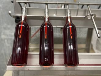 Three bottles of rosé being filled with Marechal Foch grape rosé