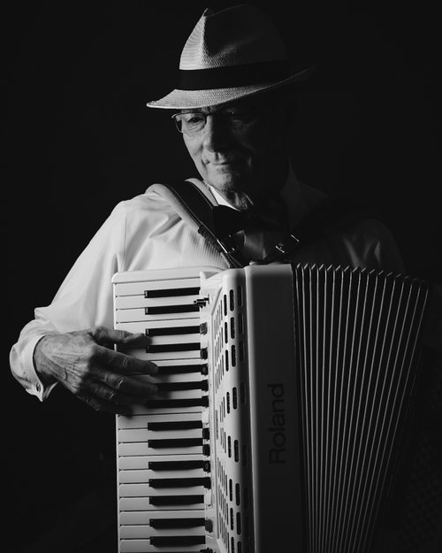 A person playing an accordion

Description automatically generated