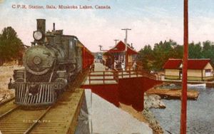 Colourized Post Cards. This card began as a 'real photo' scene of Bala, Ontario that was then colourized and printed in quantity for the lucrative
Muskoka tourism market. Even with the added colour, it retains enough detail to be worthwhile for historical research. Its subject matter is timely, based on the
October, 1908 cancellation date. The new CPR line between Toronto and Sudbury had just been opened from Bolton Junction to Bala the previous year. Bala
itself had a 'winter' station right in town as well as this photo's 'summer station' that allowed easy access to the Muskoka Lakes
steamship wharf at the lower right. Author's Collection