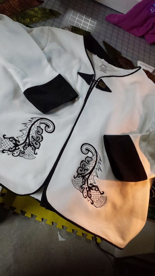 Upcycled sweatshirt to a cardigan with machine embroidered thistle on the front corners.