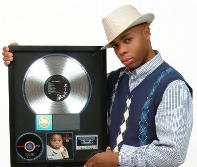 CHICAGO PRODUCER CHA LO SNUBBED FOR PRODUCTION OF “A MILLIE”?
(that there is Cha Lo, with his platinum plaque for Lil Wayne’s “A Millie”)
Story courtesy of Fake Shore Drive Editor; Andrew Barber
Now I remember back in the glorious days of summer (whatever happened to those anyway), Boogz did a post over on his blog and kept telling me that this kid Cha Lo, from Chicago, was the guy who actually created the beat for “A Millie” over three years ago. I just figured he was some kind of understudy, or maybe he had just laid the skeleton for the track, or the drums or something.
Lo and behold, this man was the co-producer & basically the man behind the track. A journalist by the name of Rahiem Shabazz has uncovered the full story over at this blog in a post called “Two Producers, One Huge Hit, One BET Award”.
Read the Full Story courtesy of Editor; Andrew Barber.
http://www.fakeshoredrive.com/2008/10/chicago-producer-cha-lo-snubbed-for-production-of-a-millie.html/