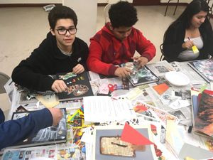 Students working on 'Identity' découpage journal covers - clipping photos, graphics and words to personalize their class notebooks.