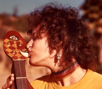 Picture of Joellen kissing the Jester peghead which became the cover of the 1st edition of Lapidus on Dulcimer
