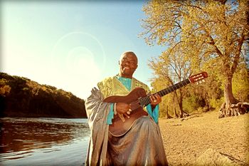 Siama playing guitar at his favorite spot by the Mississippi River in St. Paul, MN (photo by Dallas Johnson)