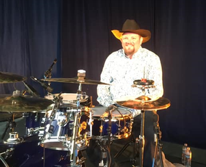 Kyle Mensing- Drums- Has been playing multiple instruments since he was 11 years old. Starting out on Trumpet, he taught himself how to play Drums. Kyle took drum lesson from the late Dave Gary, and has since given lessons himself. Having played in multiple styles including Country, Jazz, Marching Percussion, Rock, Blues, and A punk Band that was able to record in the famous Sound City Studios.