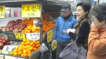 Our interpreter walking by a colorful fruit stand. She was amazing, she took care of all the details of our trip to Korea.