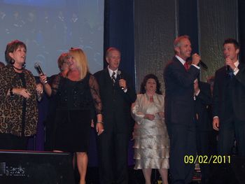 The group on stage for the Grand Finale with the Hoppers, Tribute, Triumphant, Pfiefers, and the Primitive.