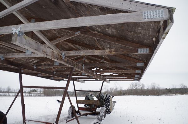 The standard roof trusses are 5 metres (16 feet) long and placed 60 cm apart (two feet) on beams made of 2 by 6 inch boards. A plywood underlay for the roof maintains rigidity while the sheet metal roof protects the sheep from rain, sun or severe wind. The two metre (7 feet) height from ground to trusses allows the shelter to pass over fence posts and human heads safely.