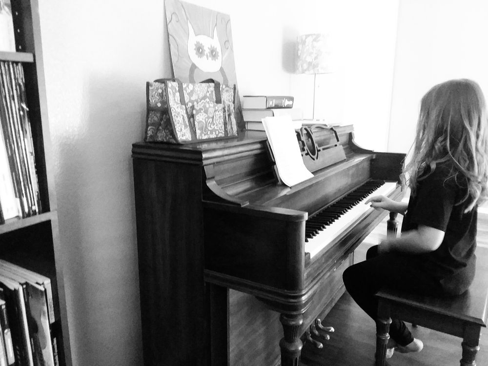 My daughter at the piano, exploring.
